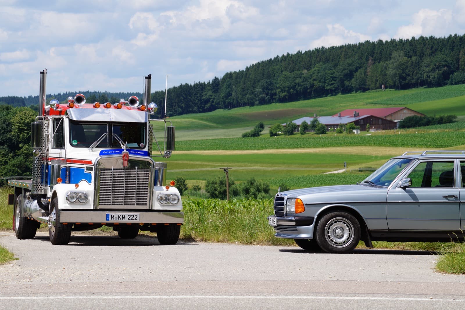 Silberne W123 Limousine neben einem US-Truck auf einer Landstraße