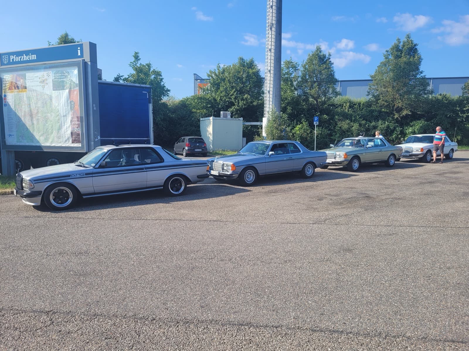 Vier aufgereihte W123 Coupés und Limousinen auf einem Parkplatz