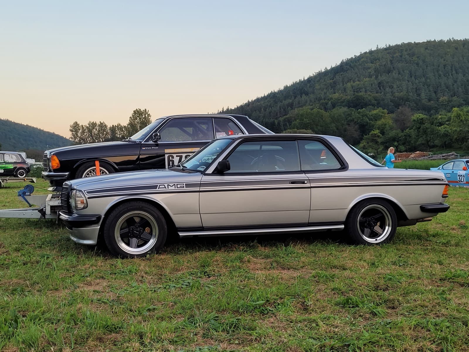 Silbernes W123 Coupé mit Alufelgen bei einem Abendtreffen