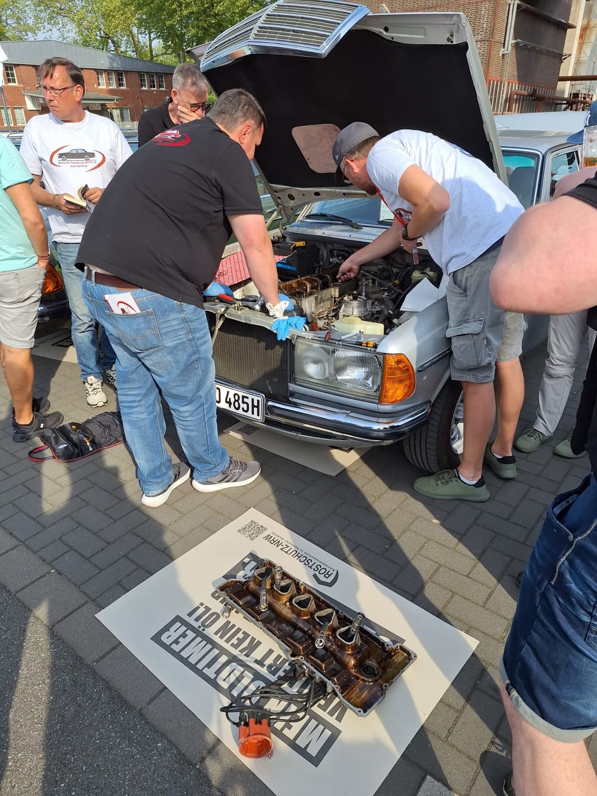 Mitglieder am offenen Motorraum eines W123 beim Technik-Stammtisch